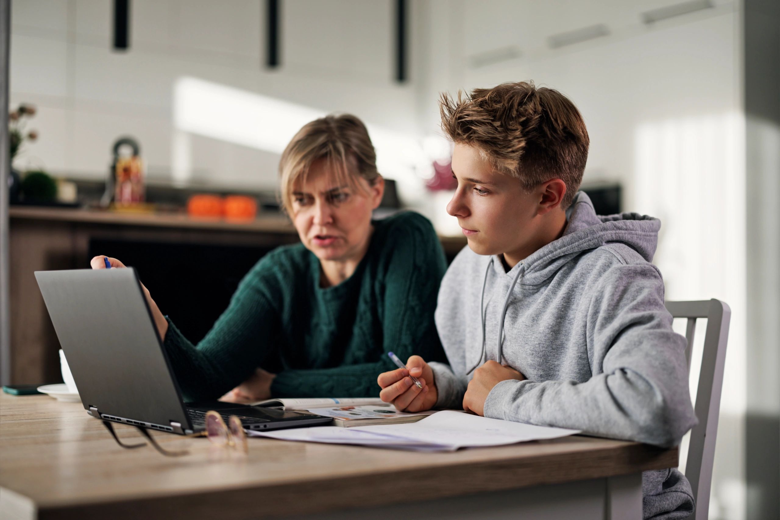 Parent helping a teenage student with homework
